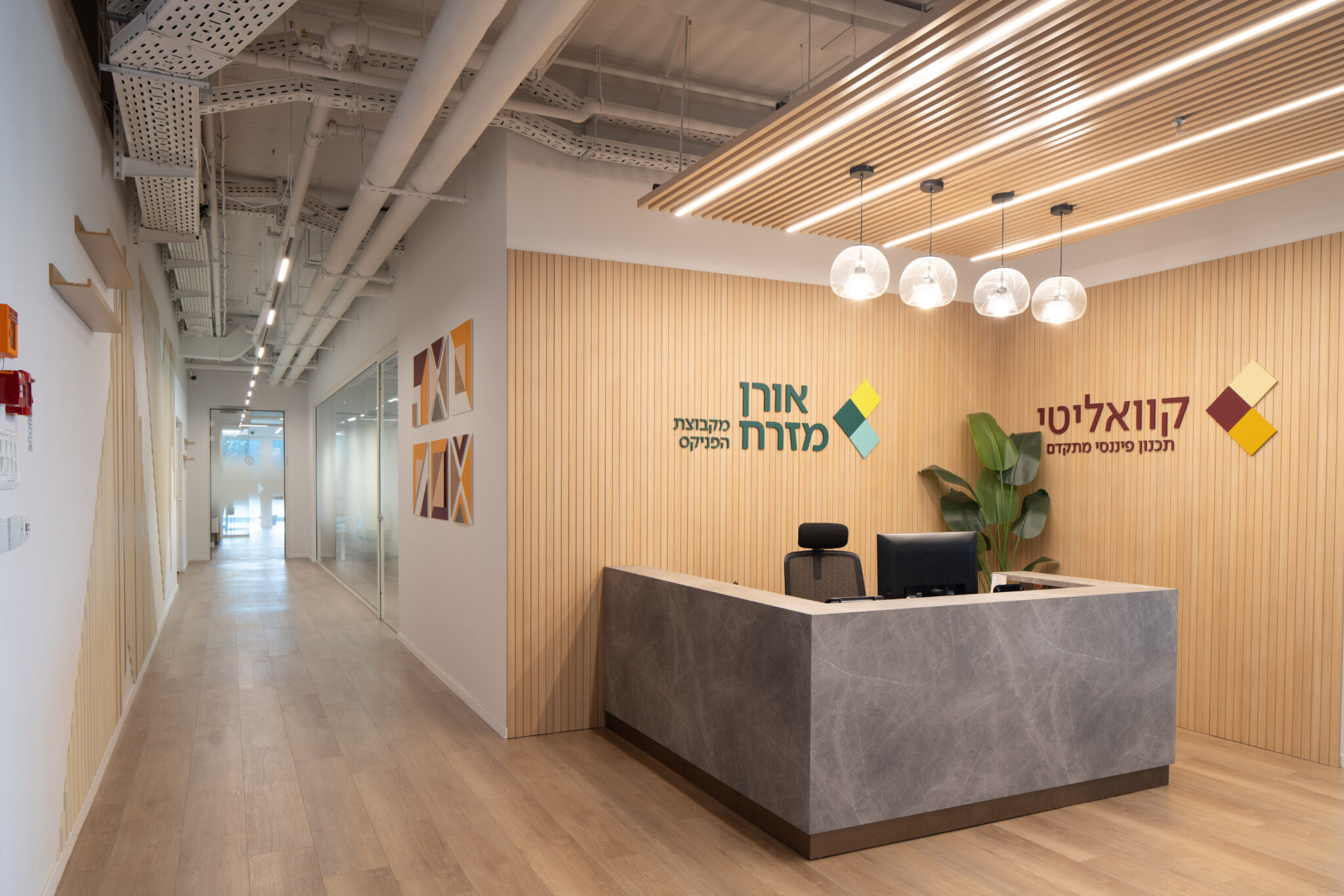 Oren Mizrah logo above a stone reception desk with wood slats