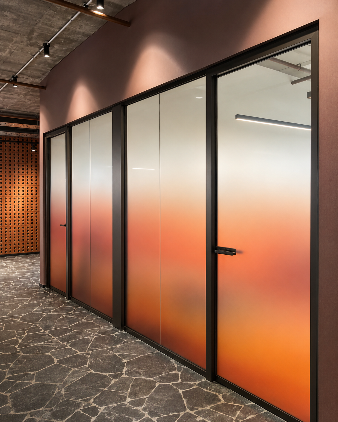 Glass wall with orange gradient film along a corridor