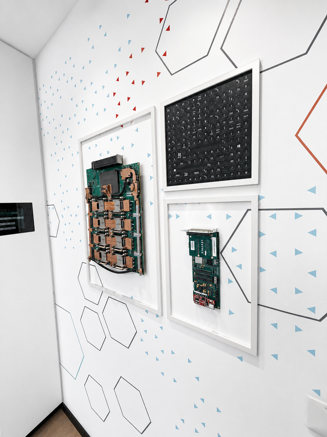 Framed circuit boards on a white wall with hexagon graphics