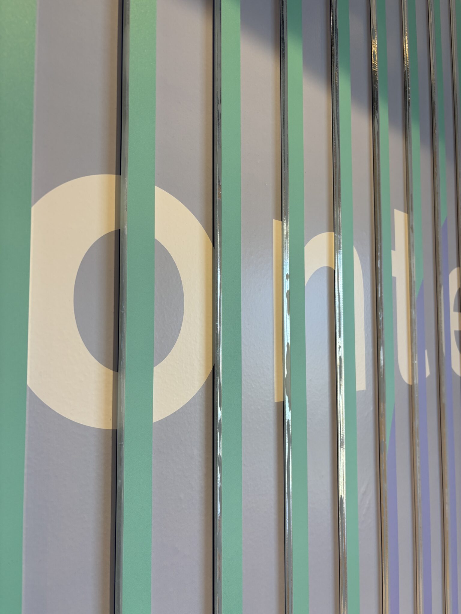 Close-up of green and blue slats with a white letter graphic