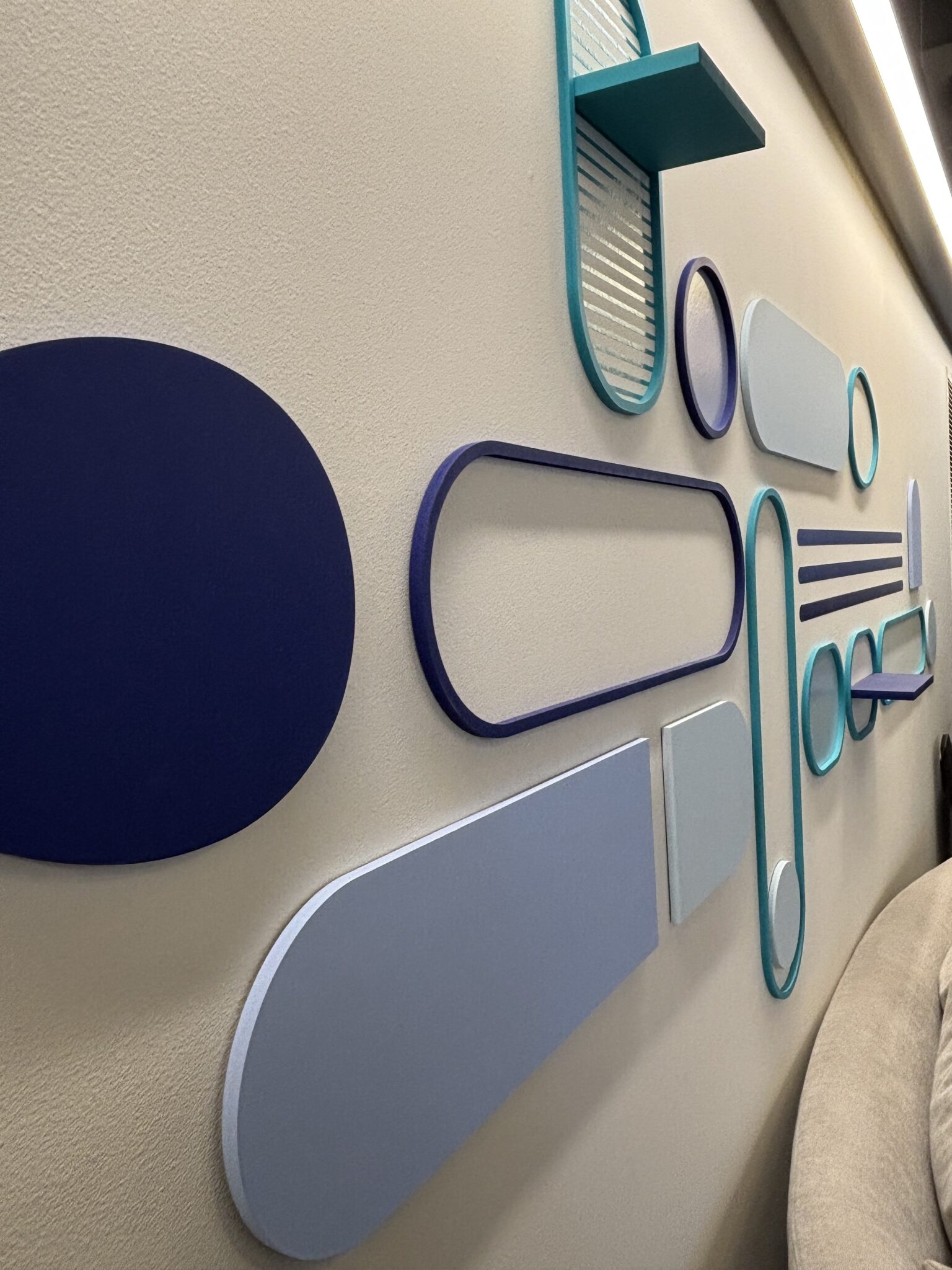 Layered 3D wall shapes in blue and teal tones