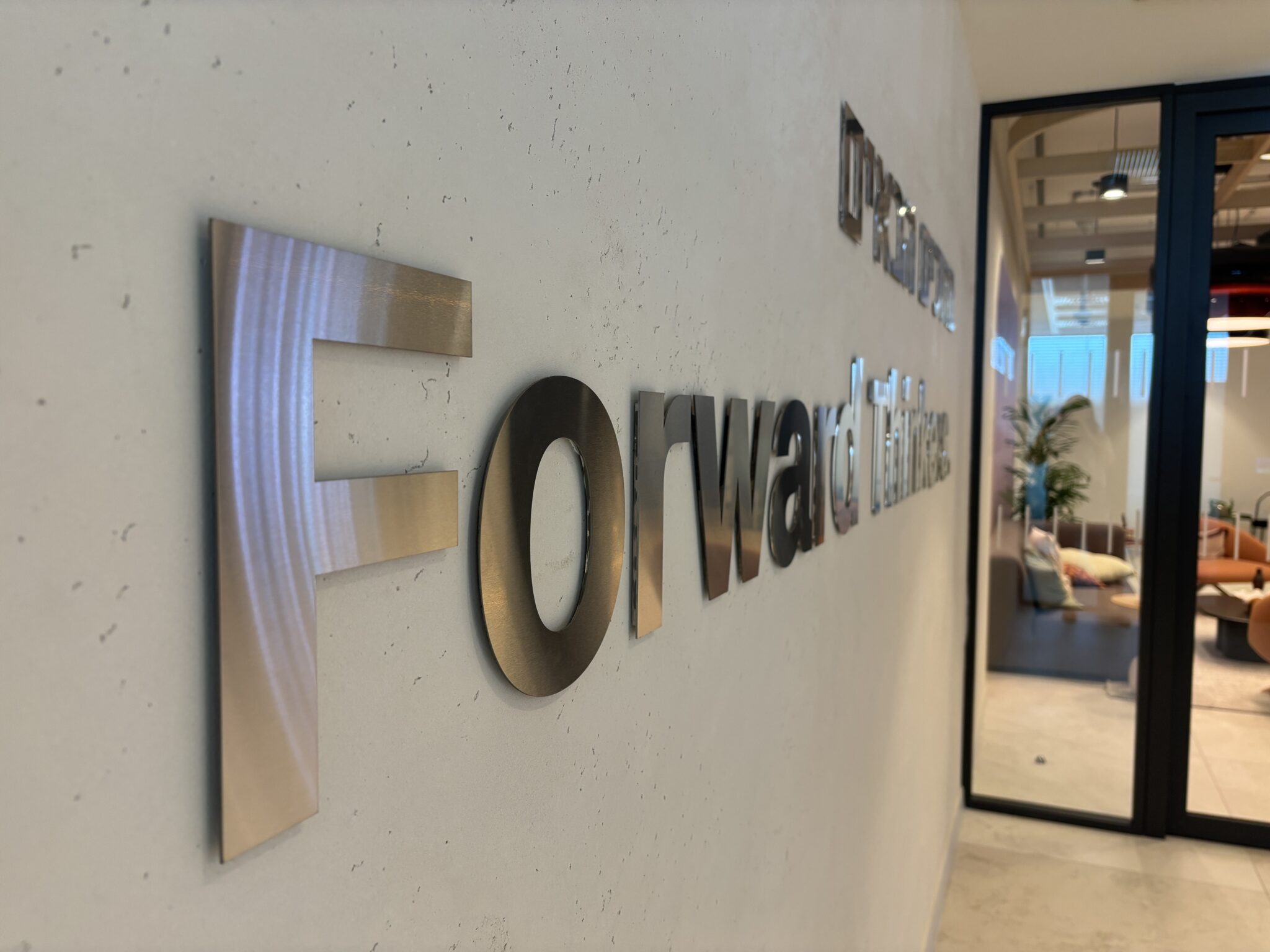 Brushed metal Forward 3D letters on a concrete wall