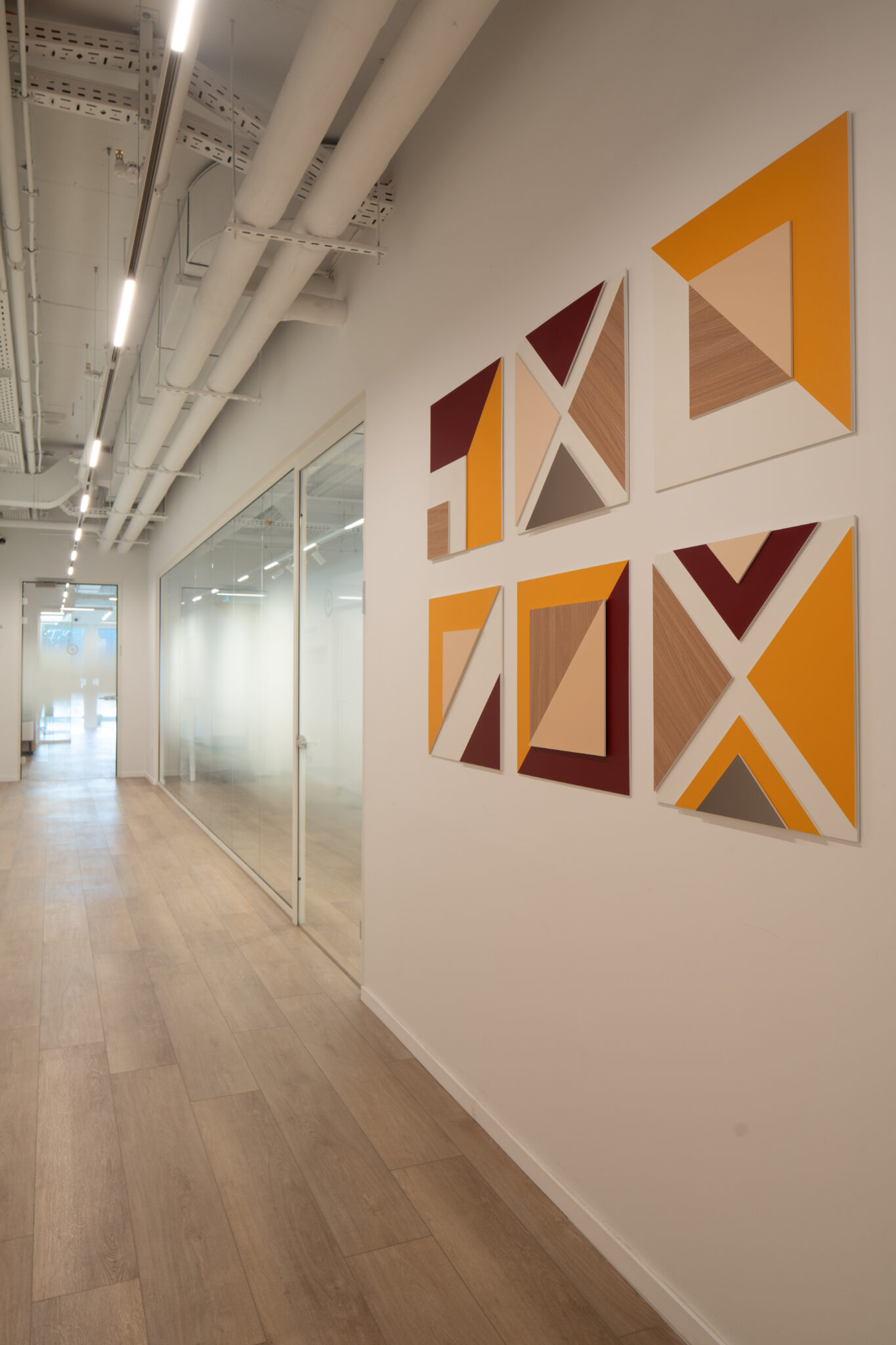 Corridor wall with orange and wood geometric triangle panels