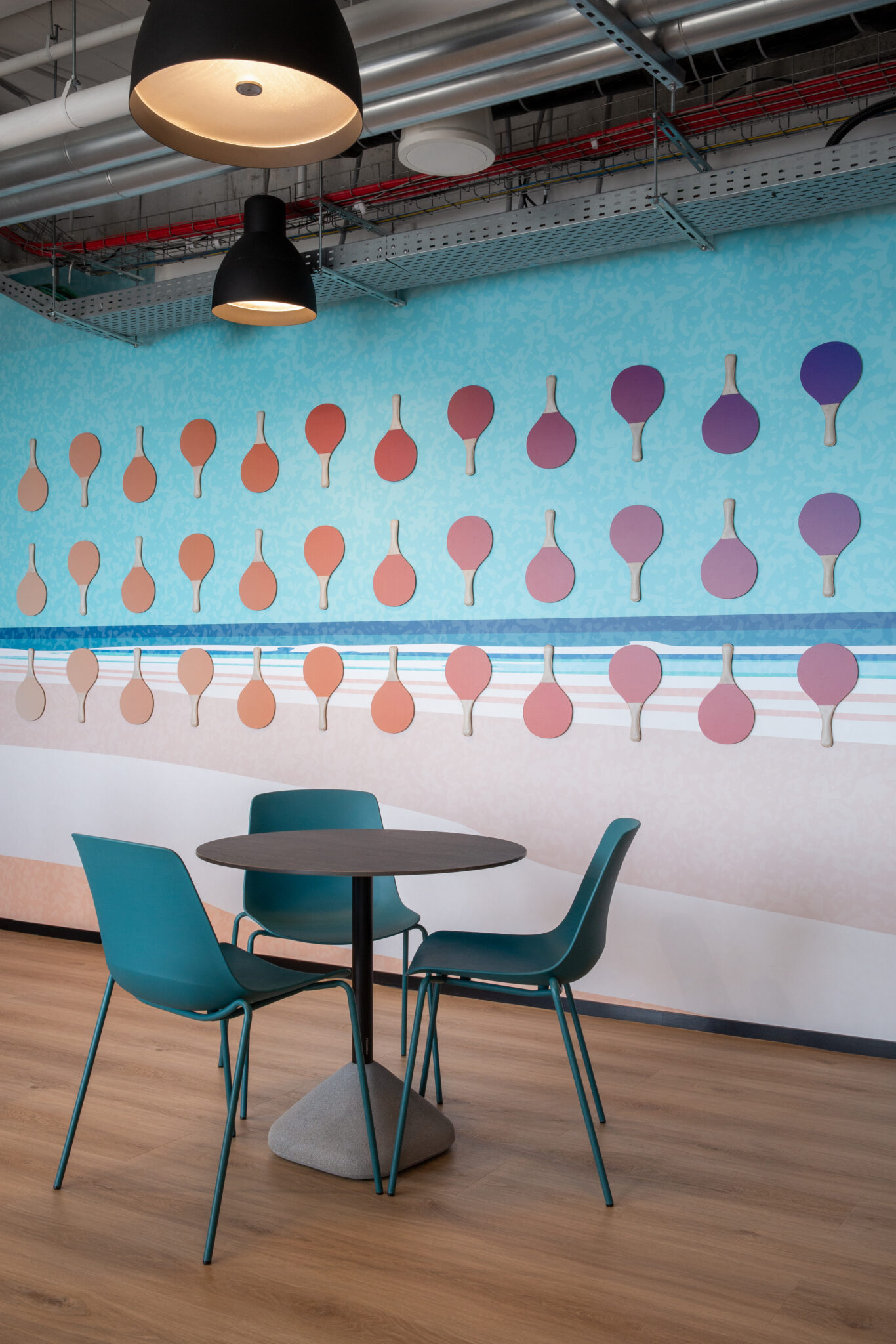 Pastel ping pong paddle shapes on a turquoise wall
