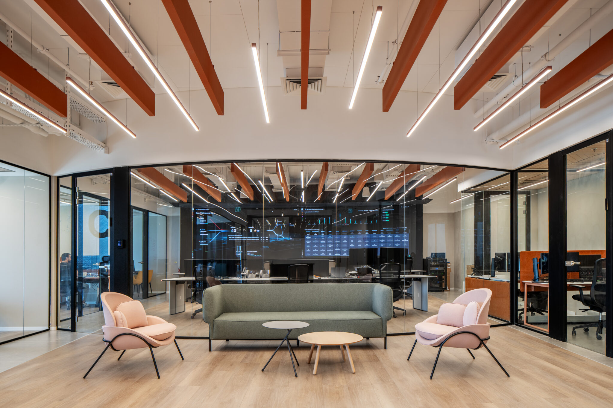 Lounge with pink armchairs under orange ceiling beams