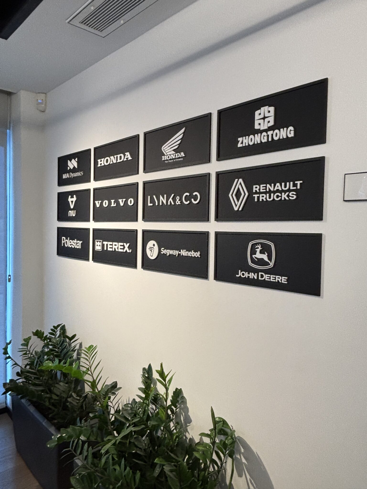 Framed client logos including Honda, Volvo and John Deere