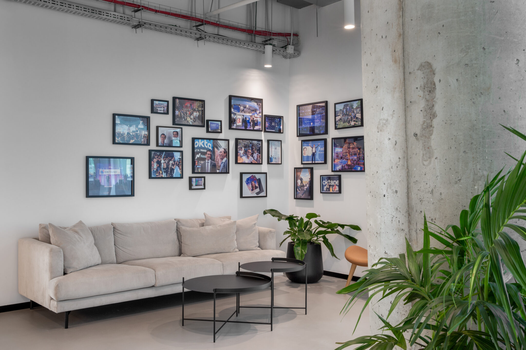 Lounge with grey sofa below a gallery wall of framed photos