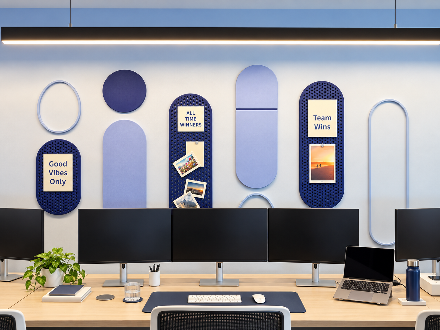 Workstations below 3D blue boards with Good Vibes Only and Team Wins
