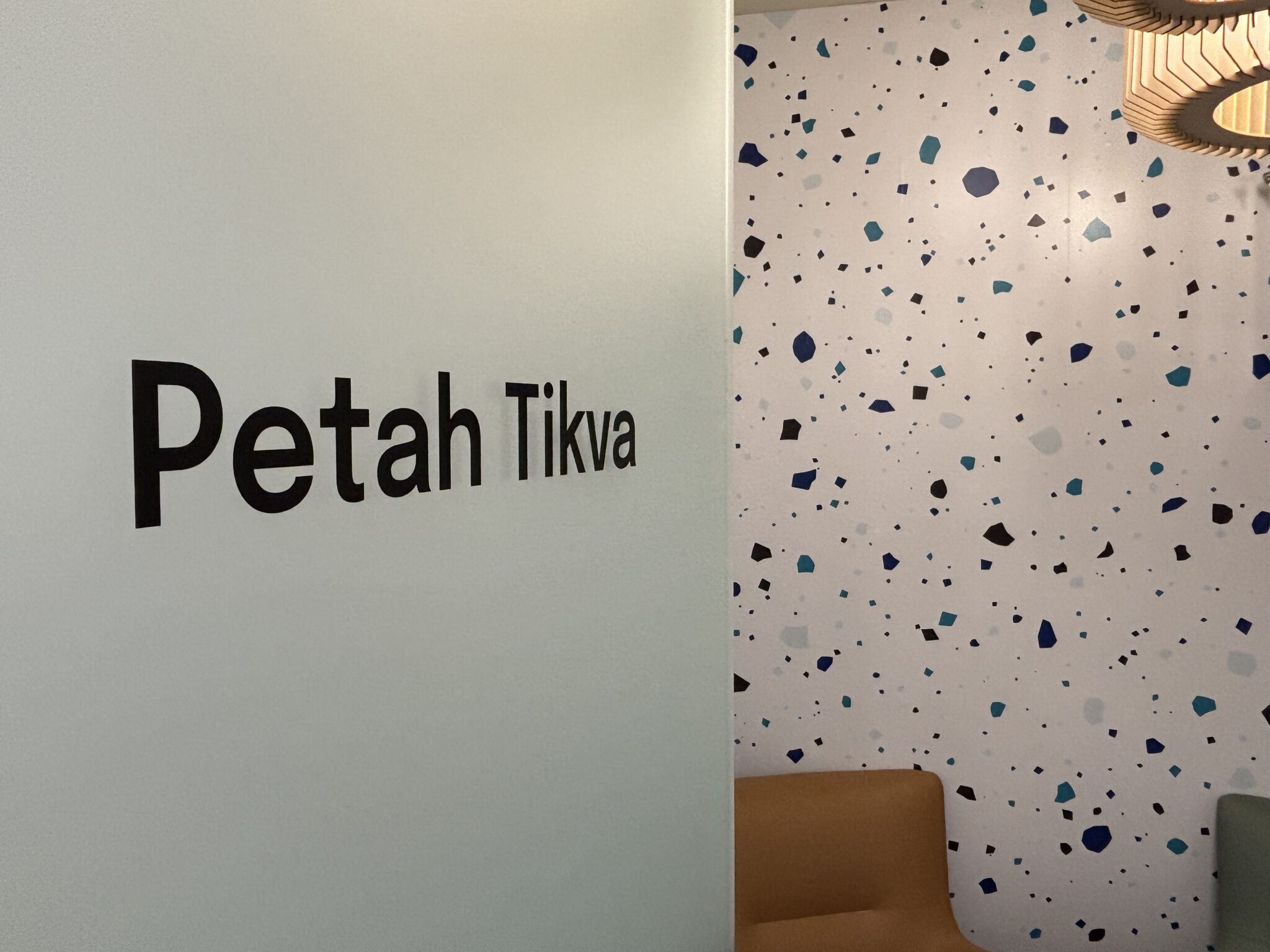 Petah Tikva room name next to a terrazzo pattern wall