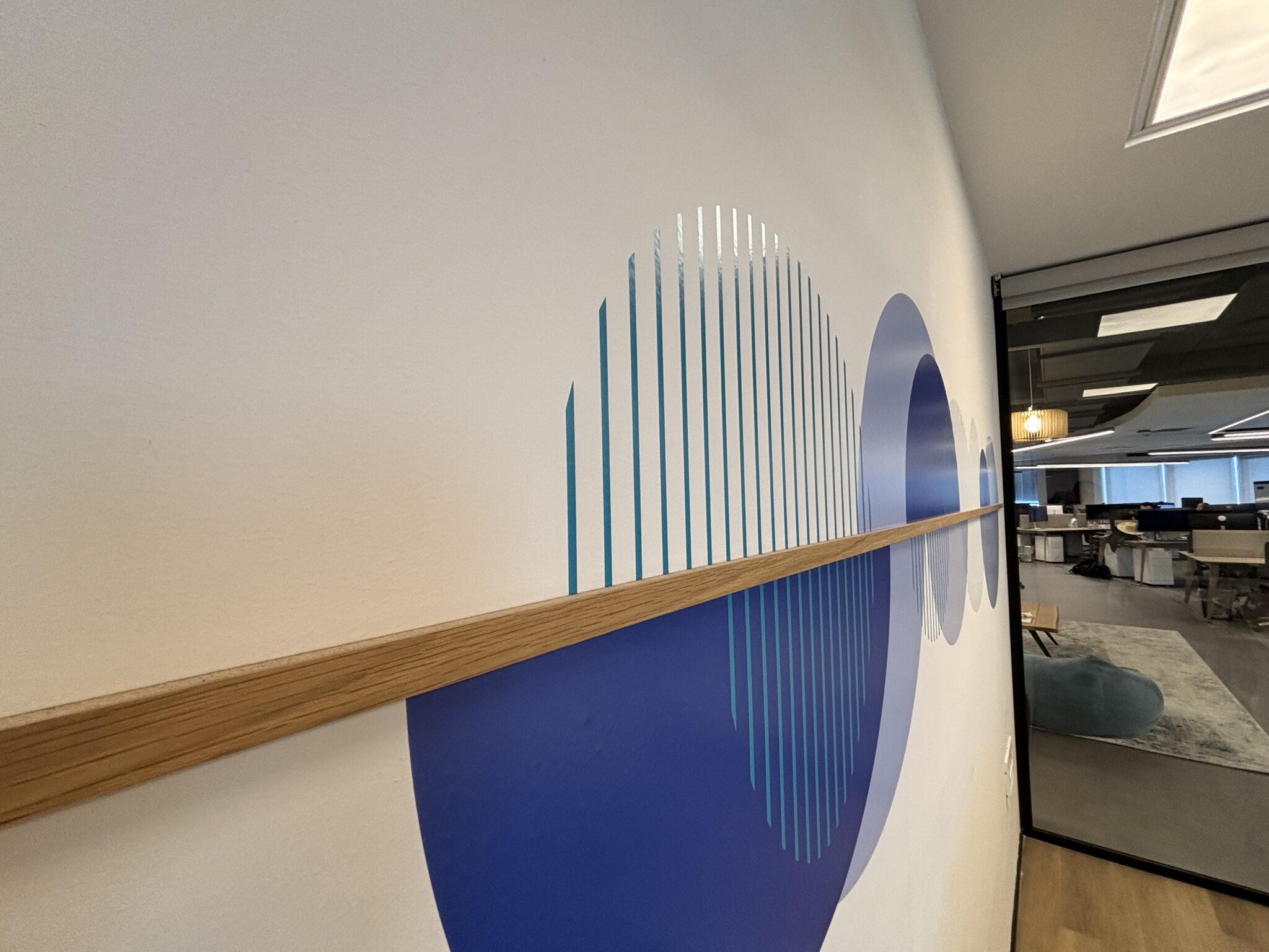 Blue circle and stripe wall graphic with a wooden rail