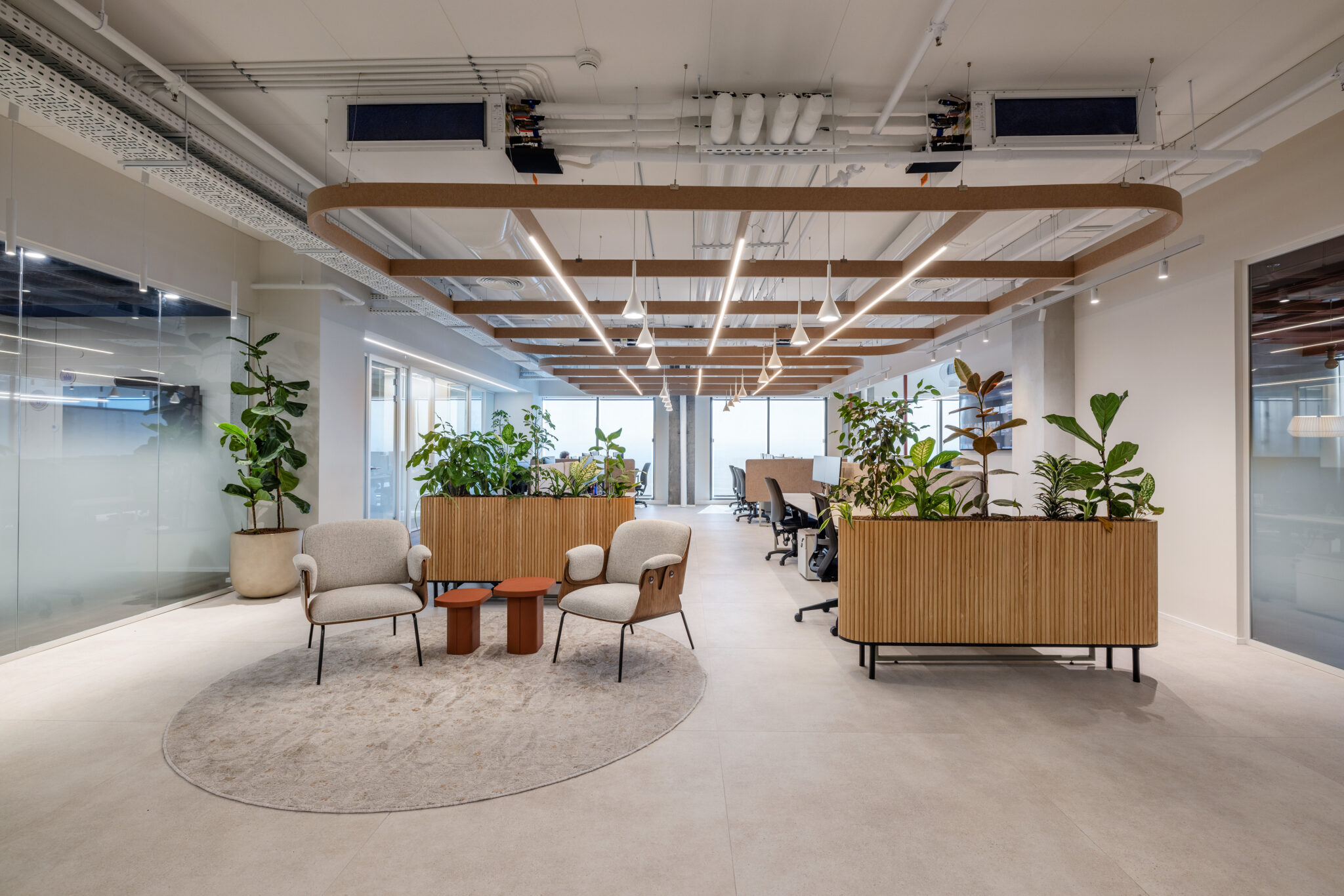 Open workspace with planters, lounge chairs and a round rug