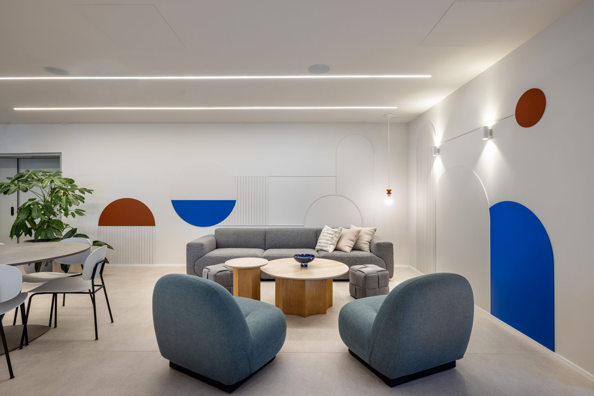 Lounge with blue armchairs and blue and orange arch wall graphics