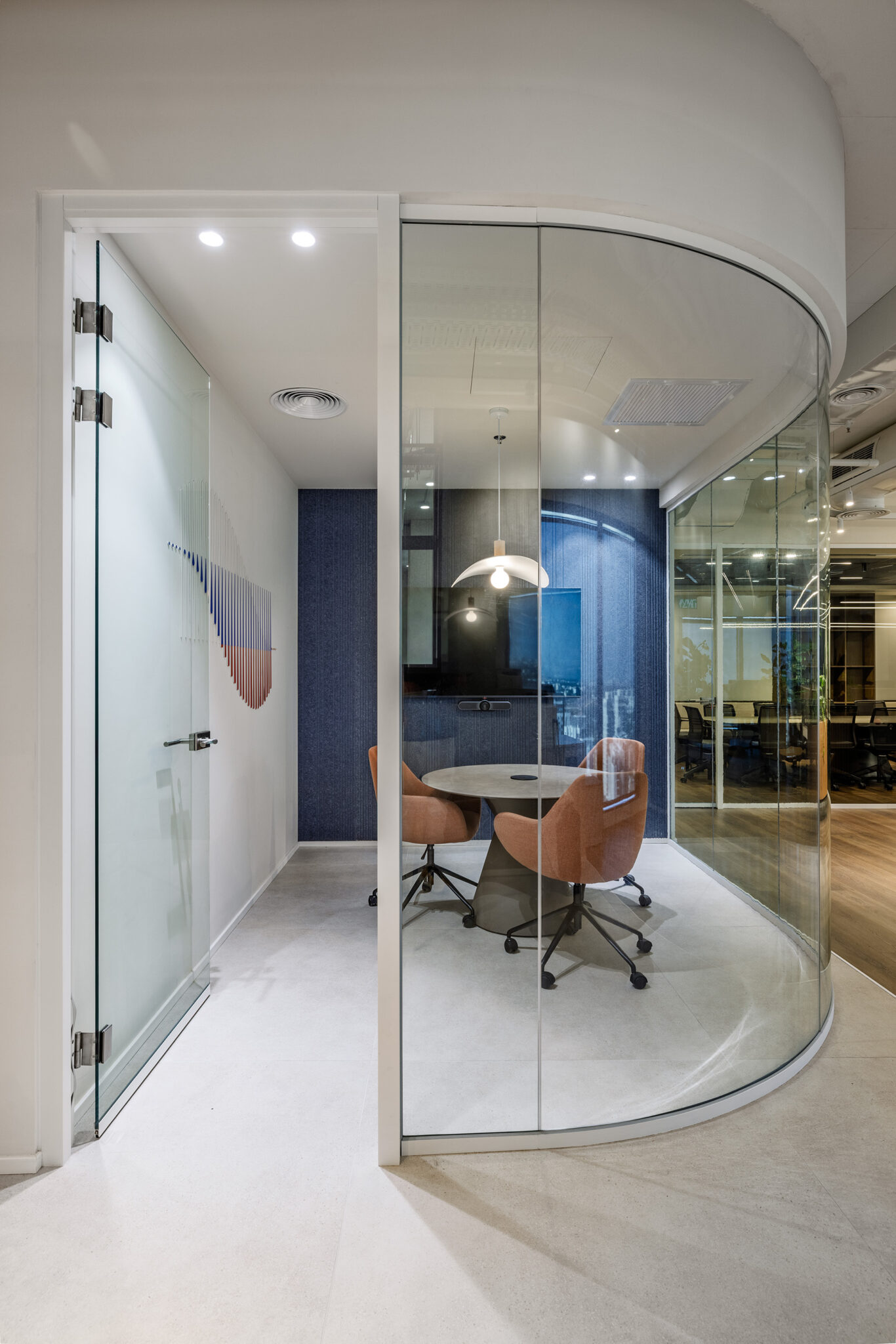 Curved glass meeting room with a round table