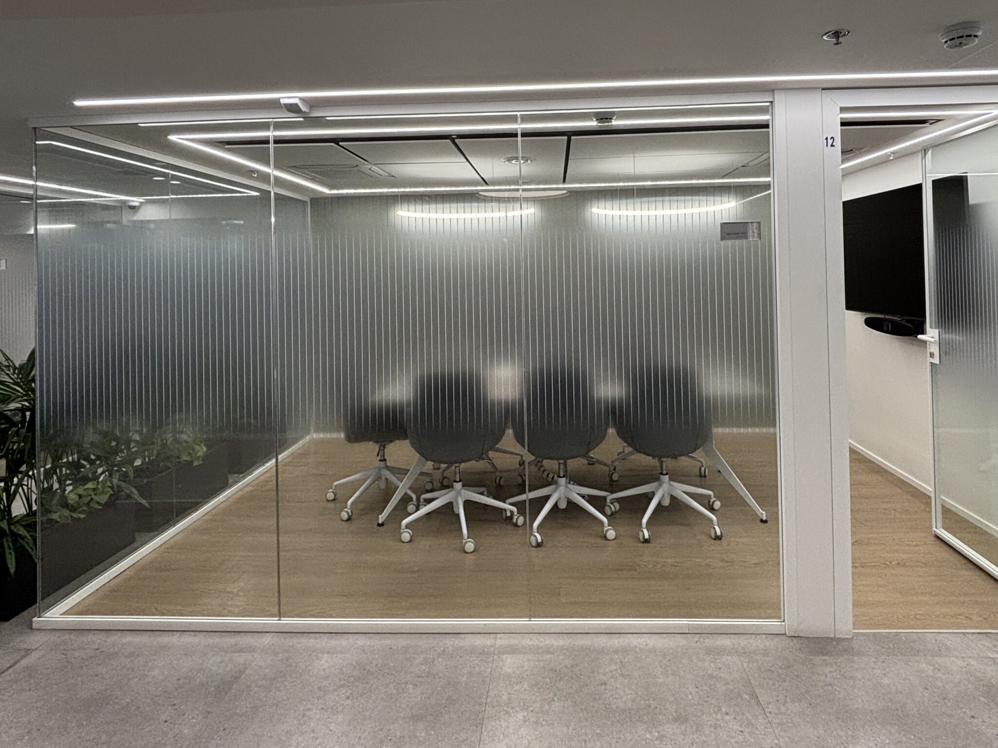 Glass meeting room with vertical stripe frosted film