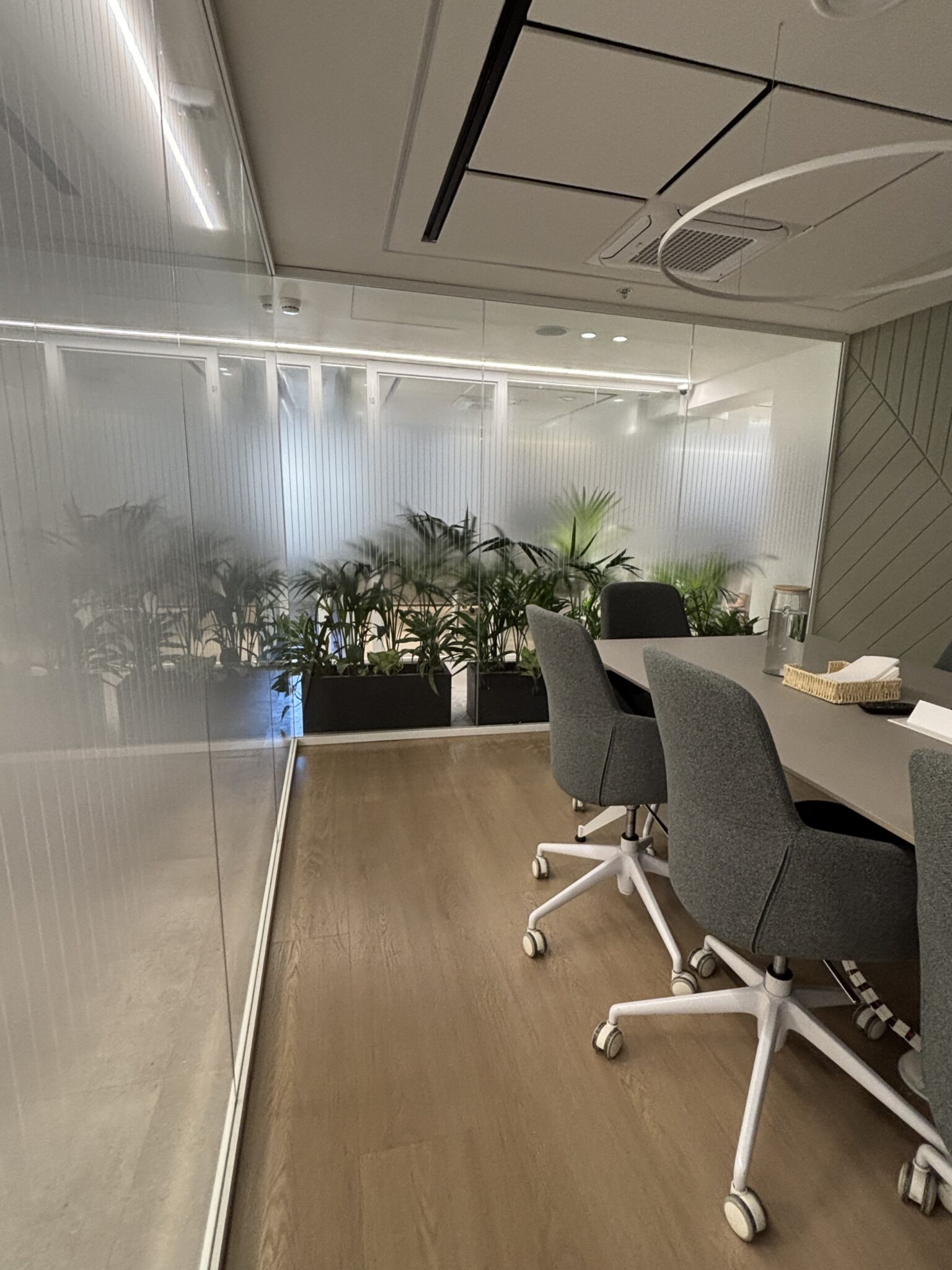 Meeting room behind glass with stripe film and planters