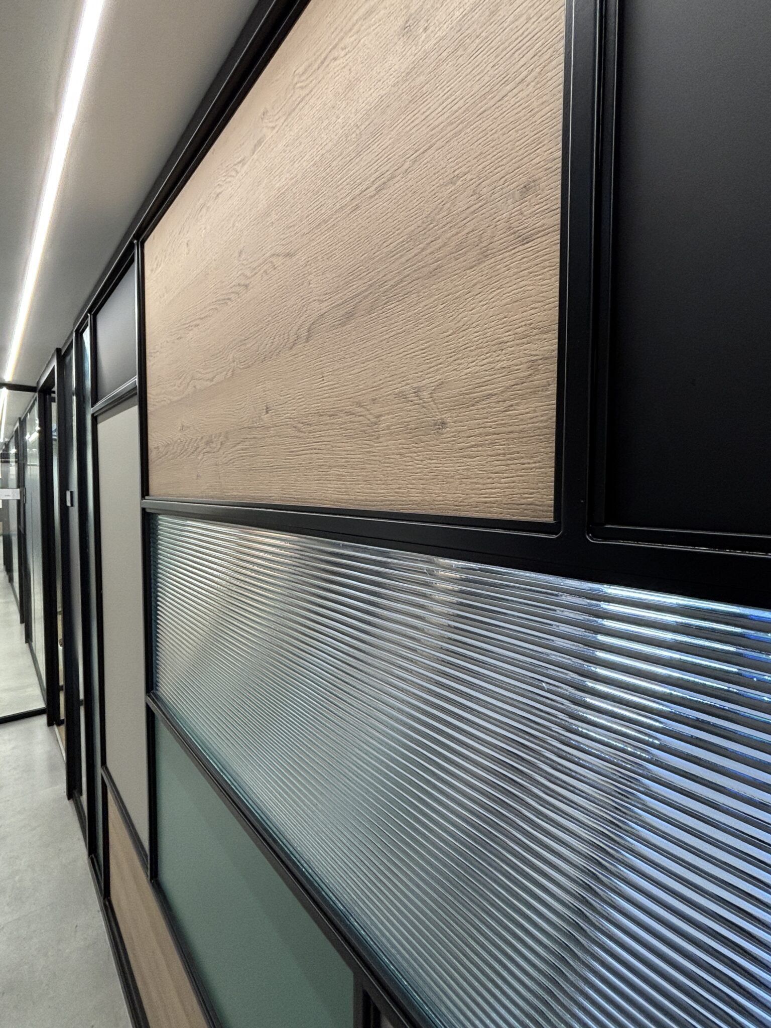 Close-up of reeded glass and wood panels in a black frame