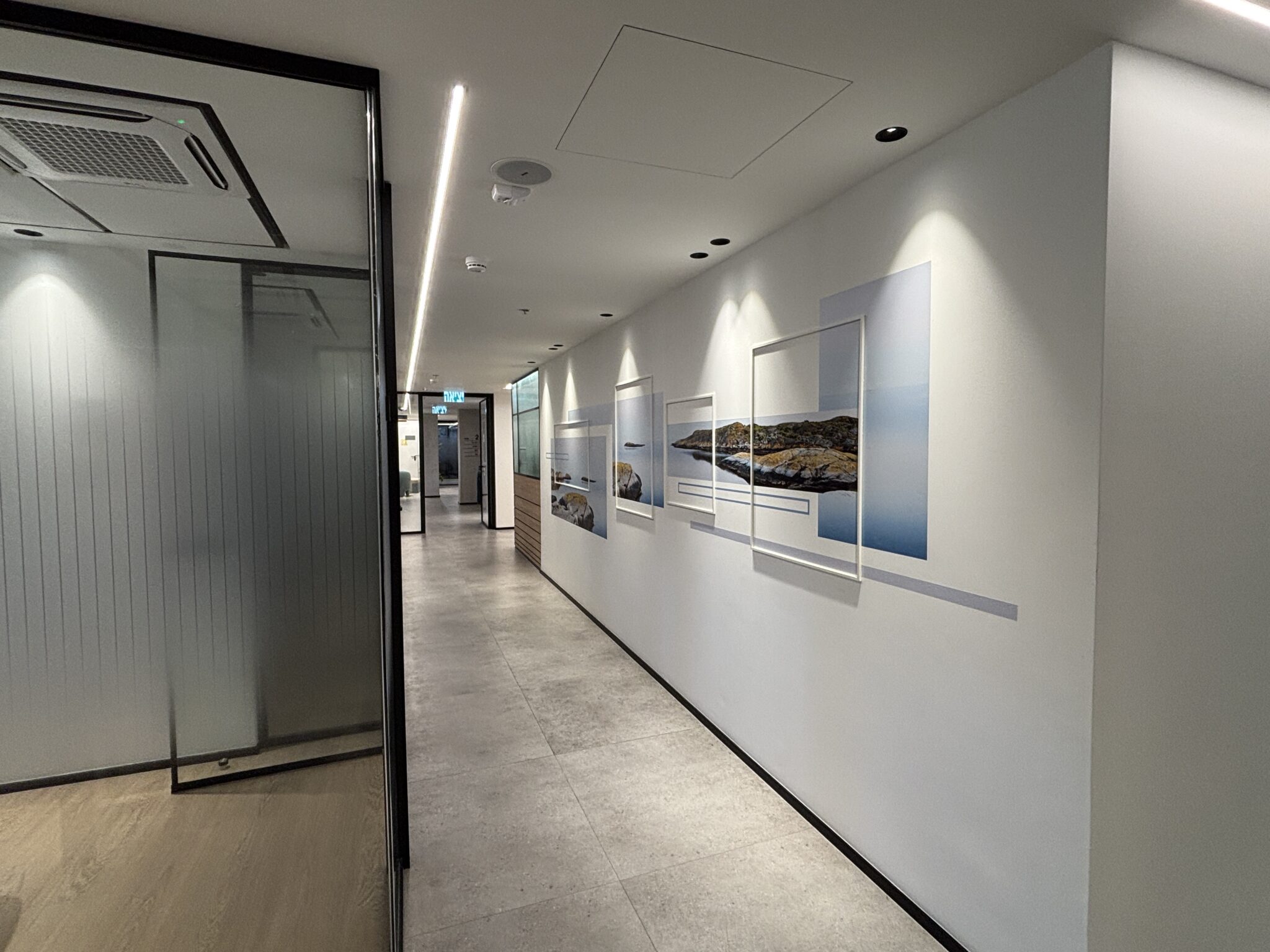 Corridor with layered framed seascape photos on the wall