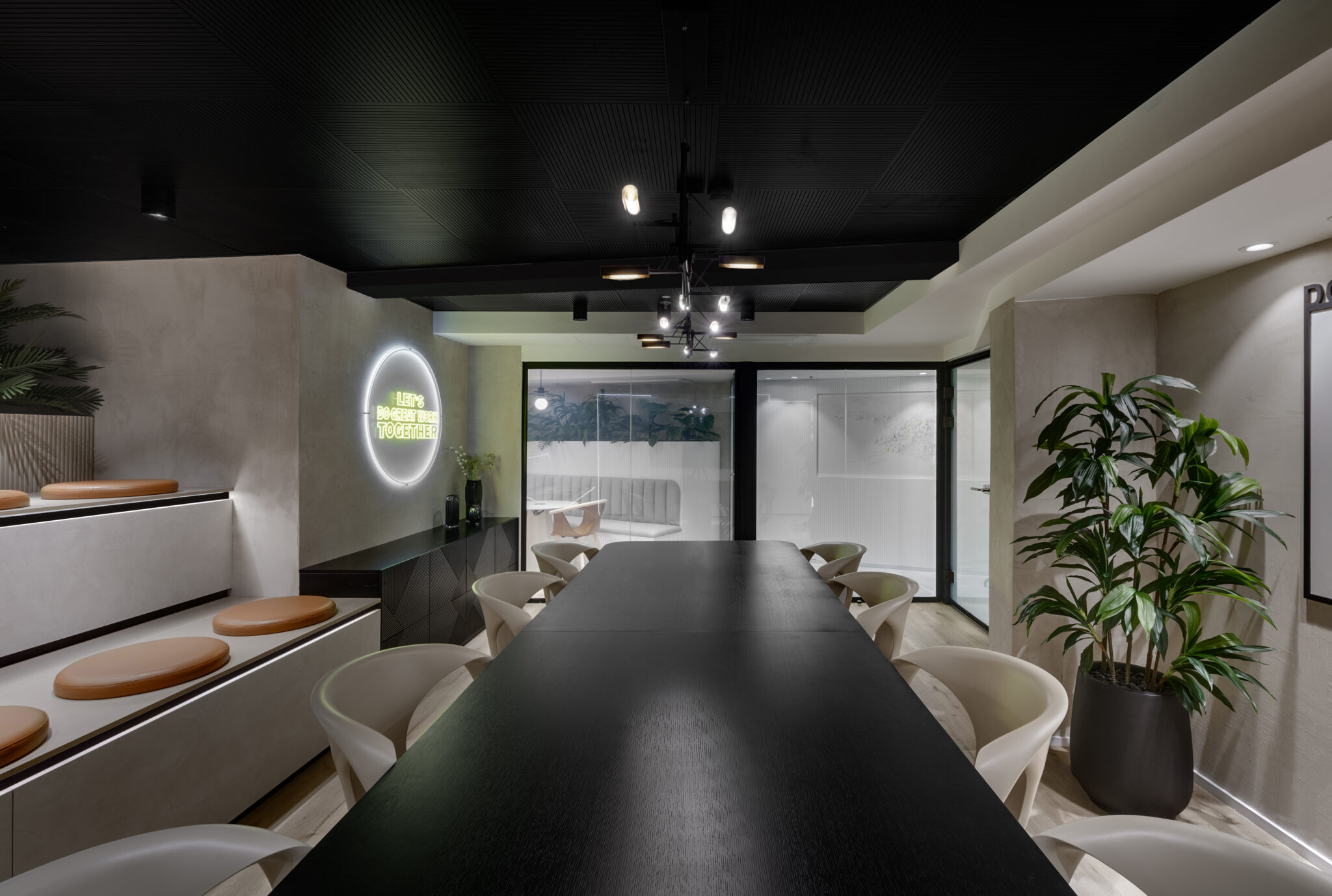 Long dark meeting table with a round neon sign