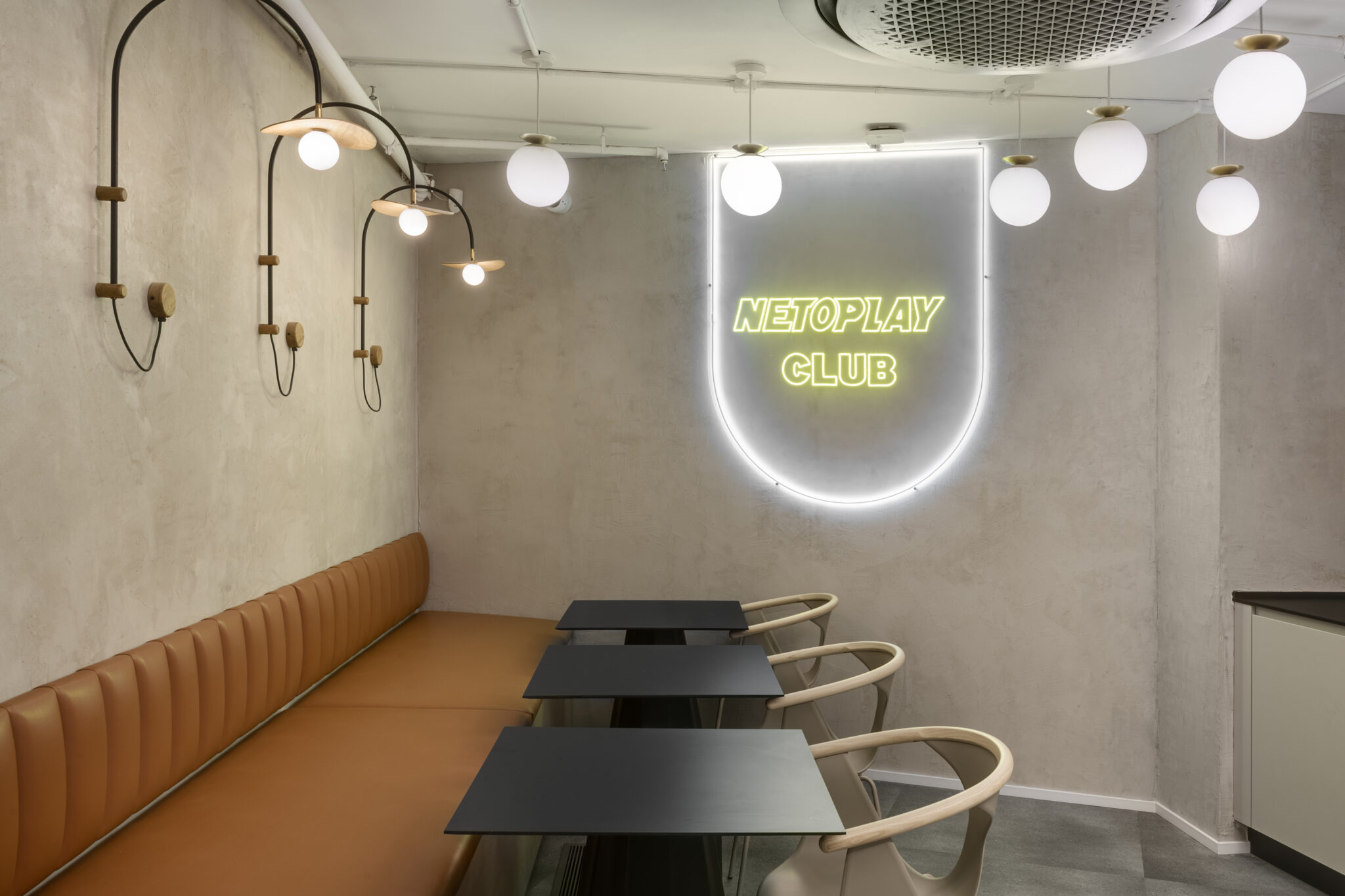 Netoplay Club neon sign in a lounge with bench seating