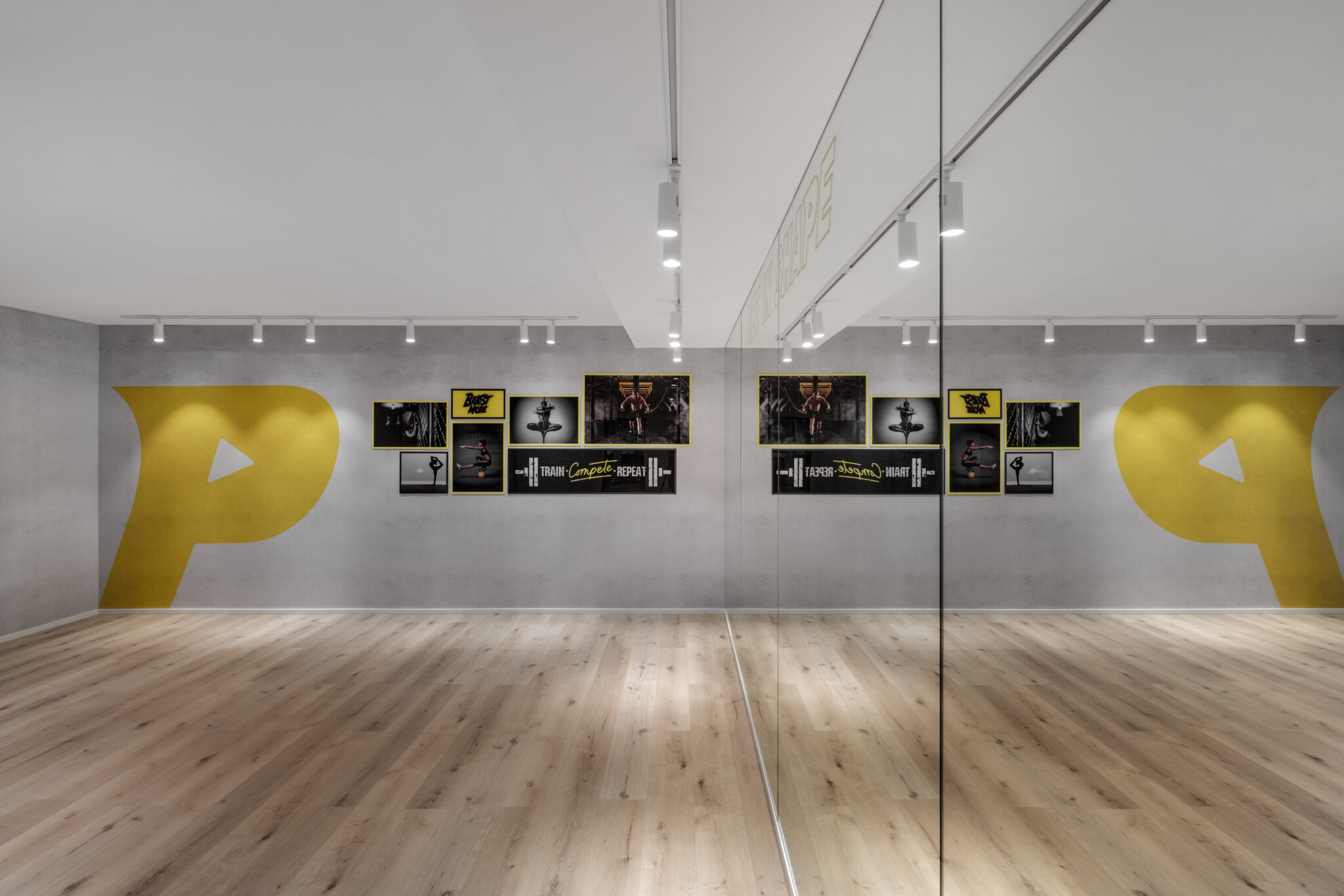 Yellow logo graphics and framed screens on a concrete wall