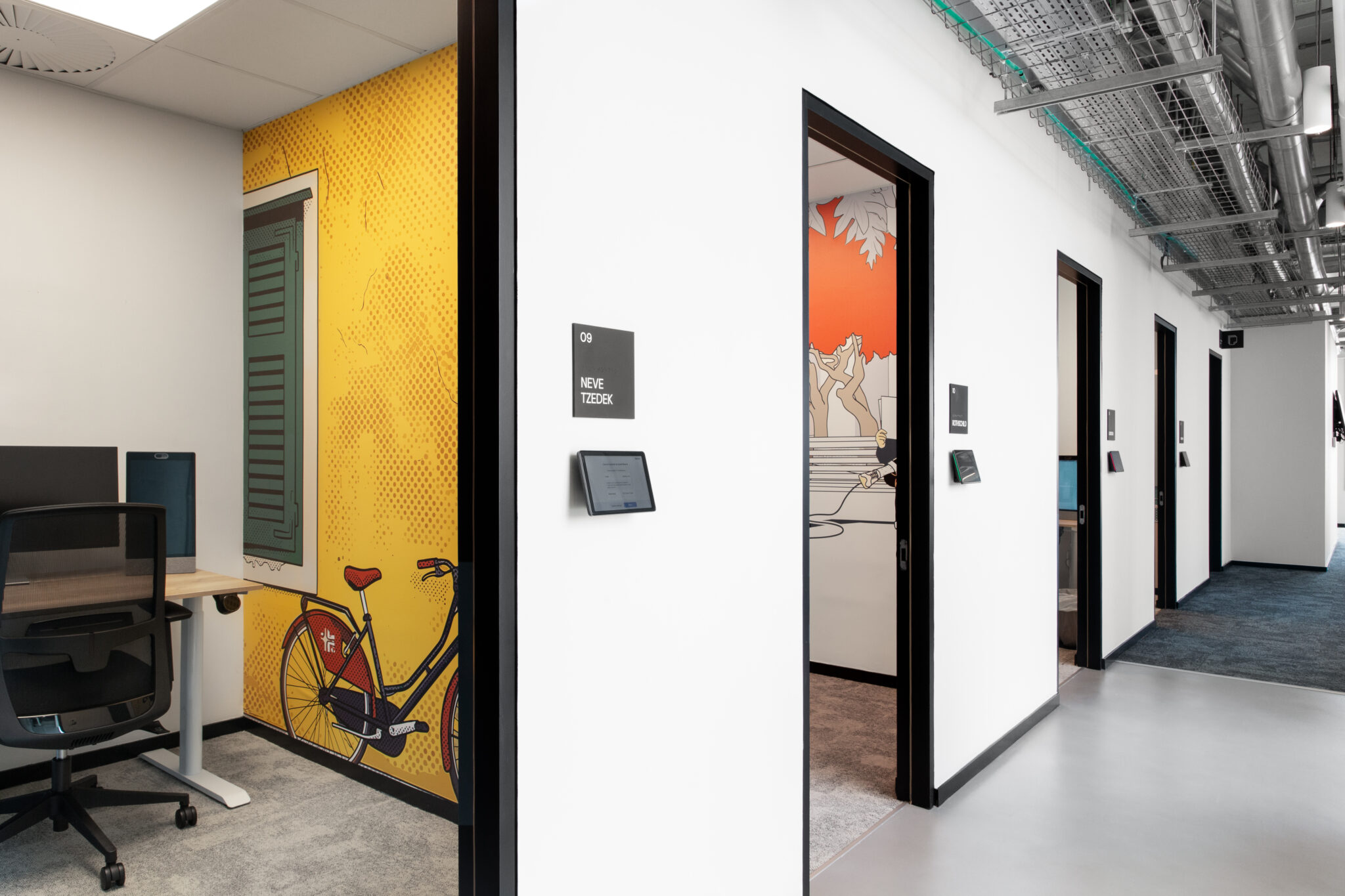Offices with a yellow bicycle mural and room name signs