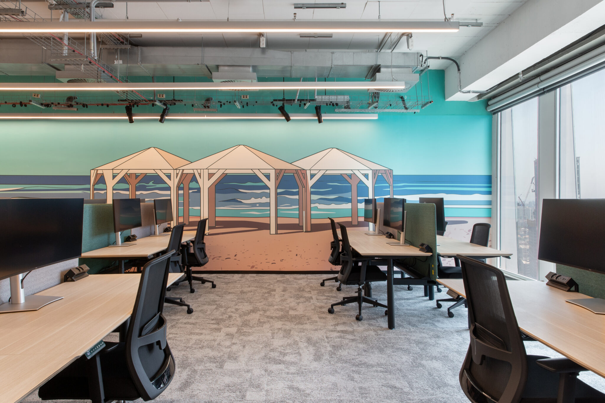 Open office with a beach umbrella and sea wall mural