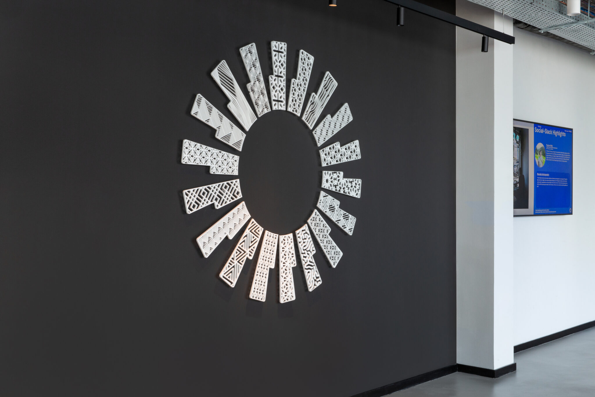 White laser-cut panels arranged in a circle on a black wall