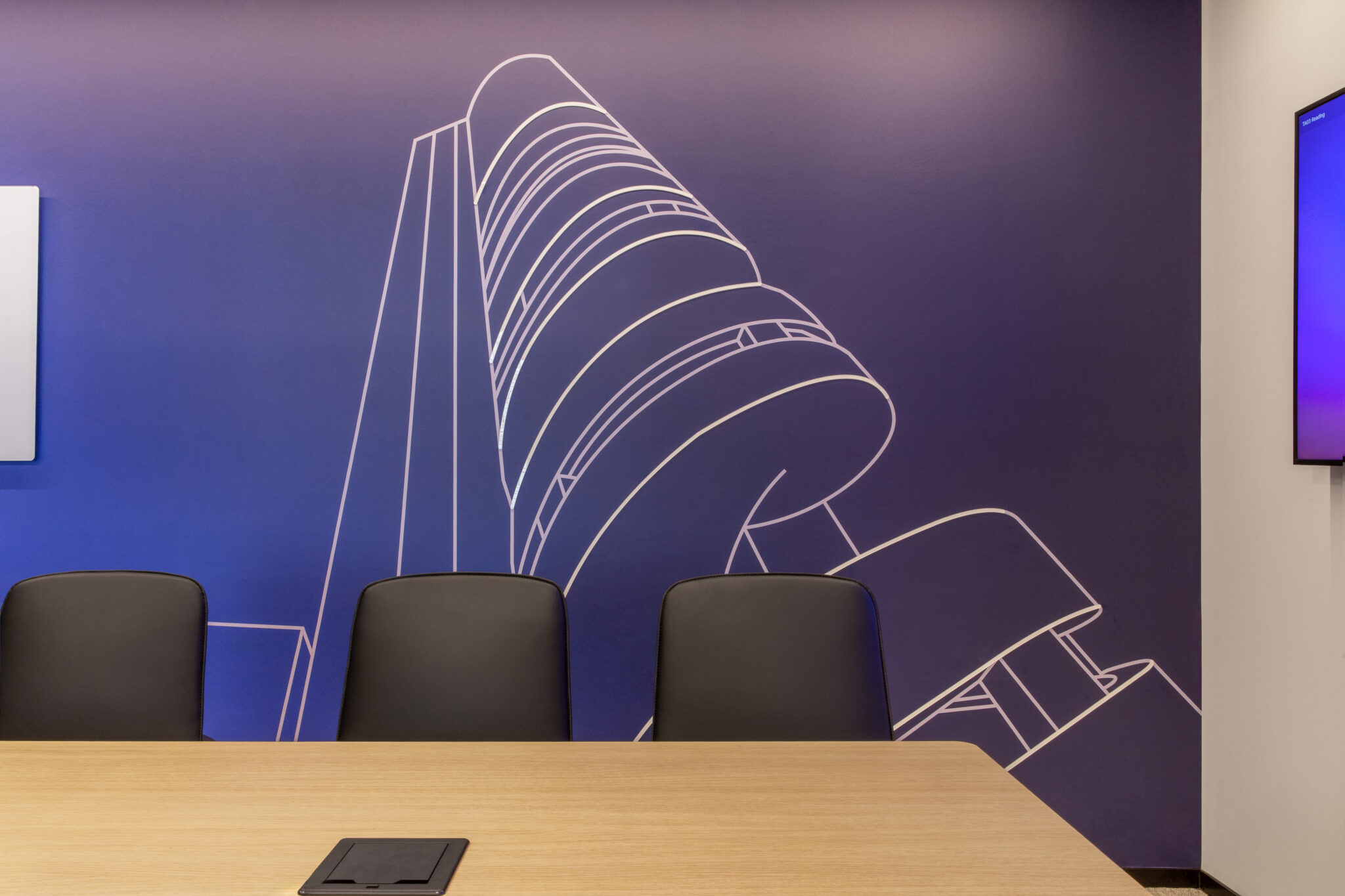 Meeting room with a white line drawing of a building on a purple wall