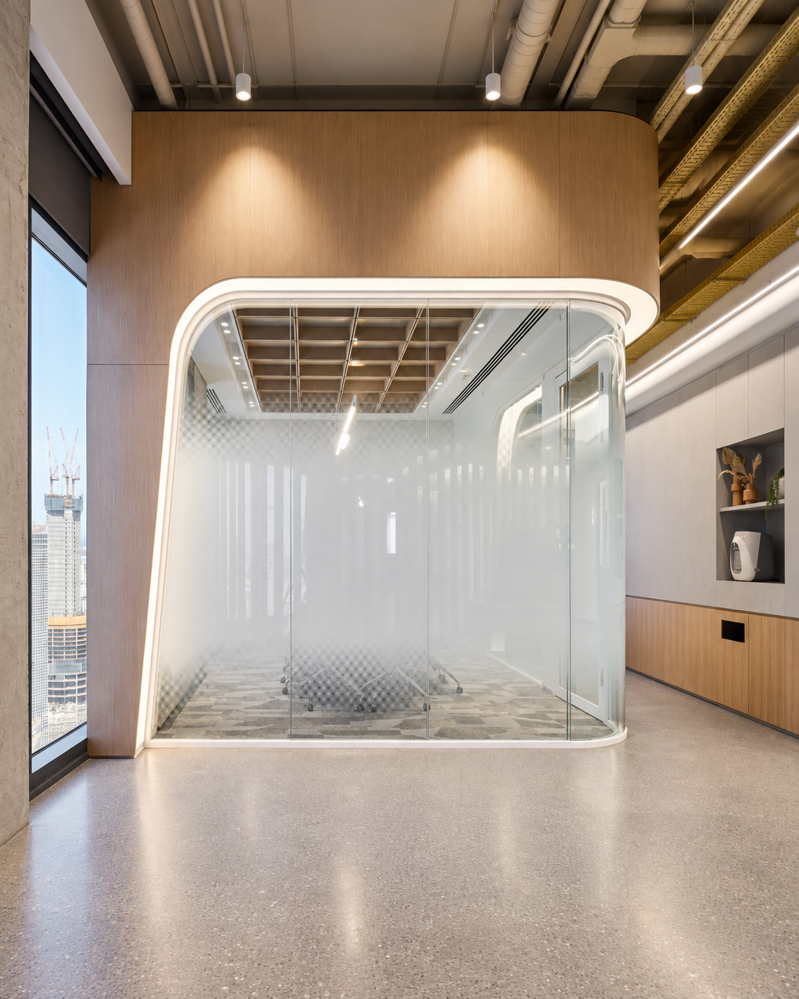 Curved glass room with a lit frame in a corridor