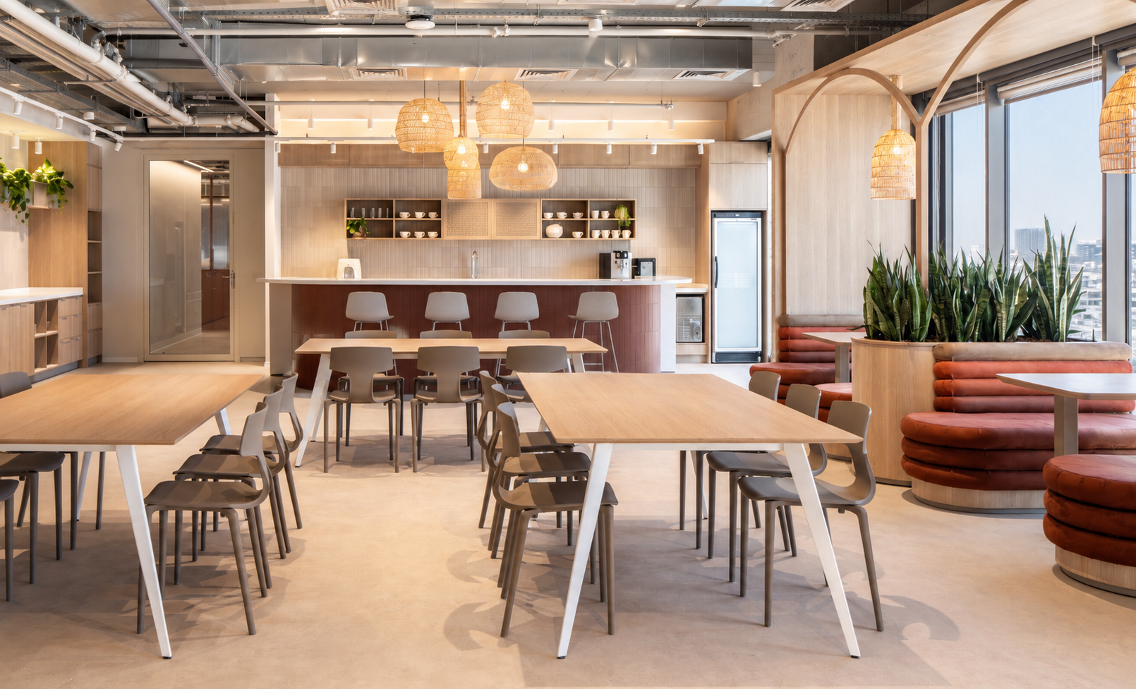 Dining area with long tables and rattan pendant lights