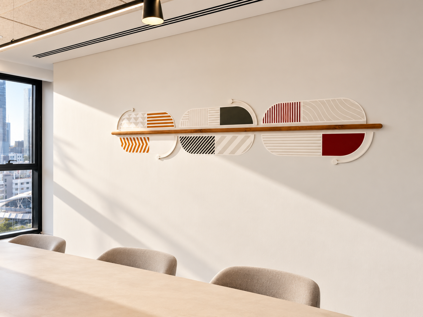 Geometric wall graphic with a wood shelf above a meeting table