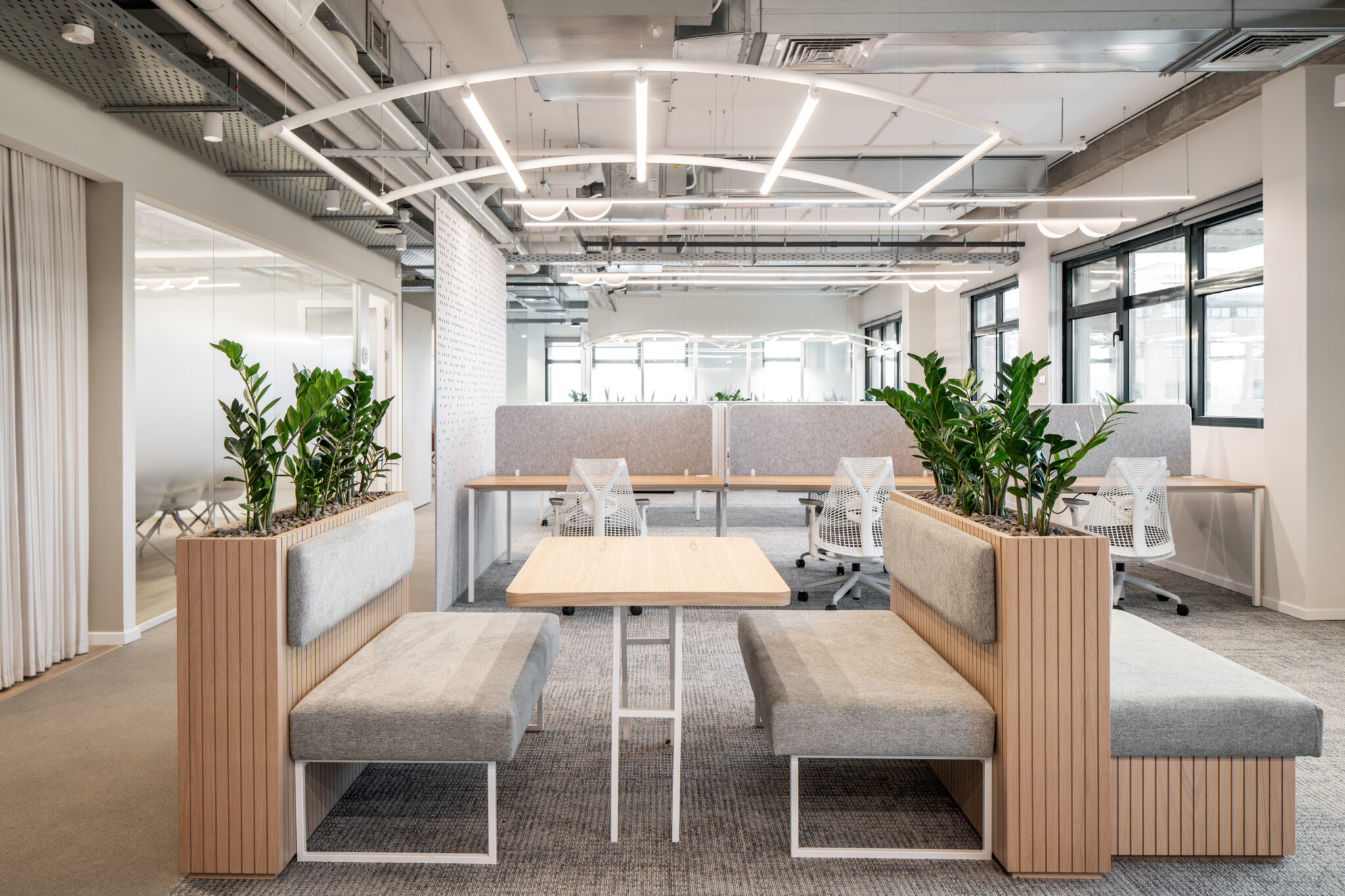 Booth seating with wood-slat planters in an open office
