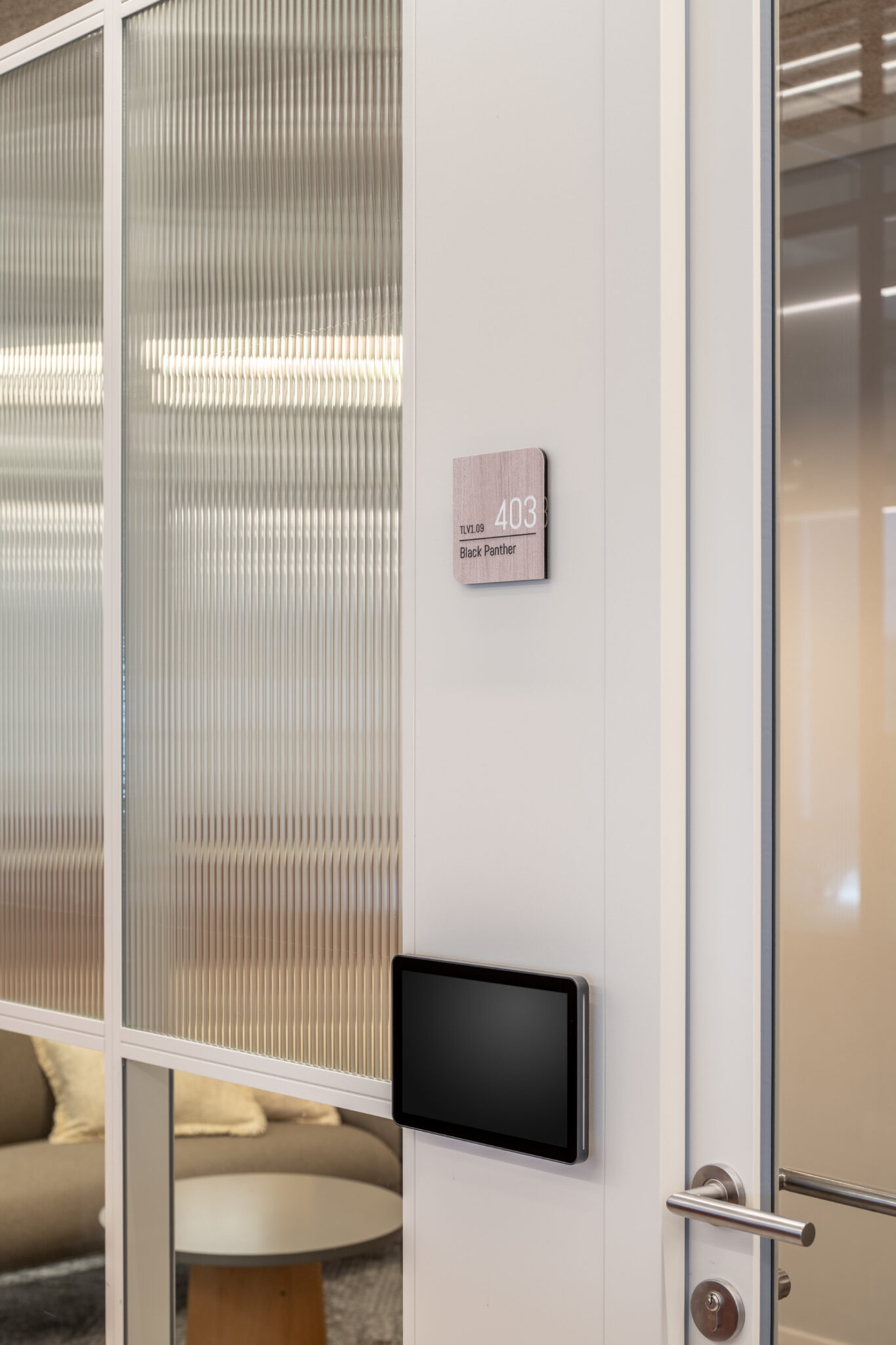 Room name sign beside a reeded glass door