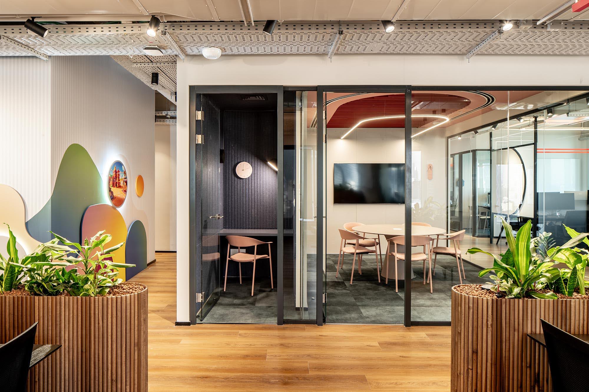 Meeting rooms with curved wall graphics and wood-slat planters