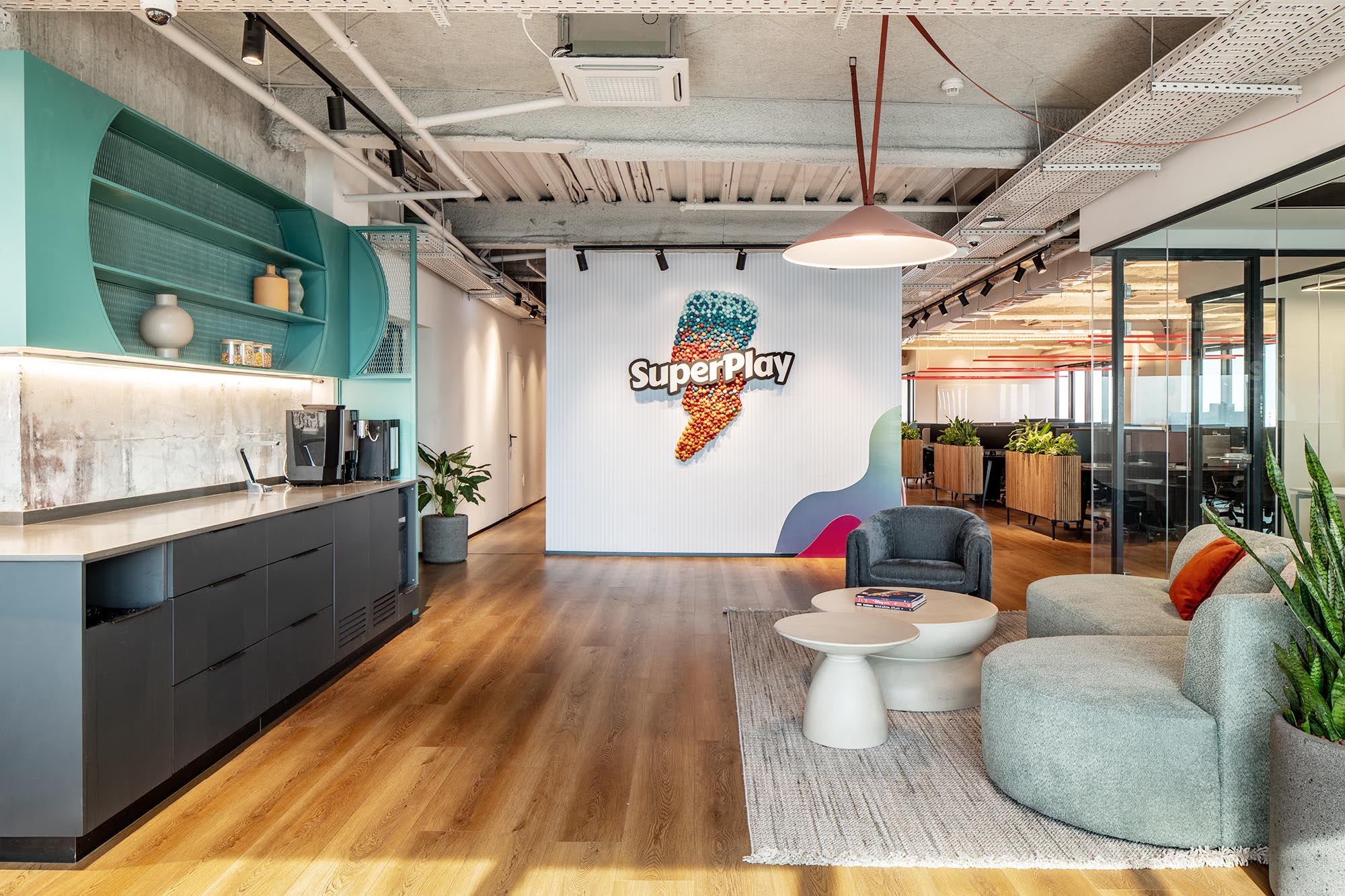 SuperPlay logo wall with a lounge and kitchen area