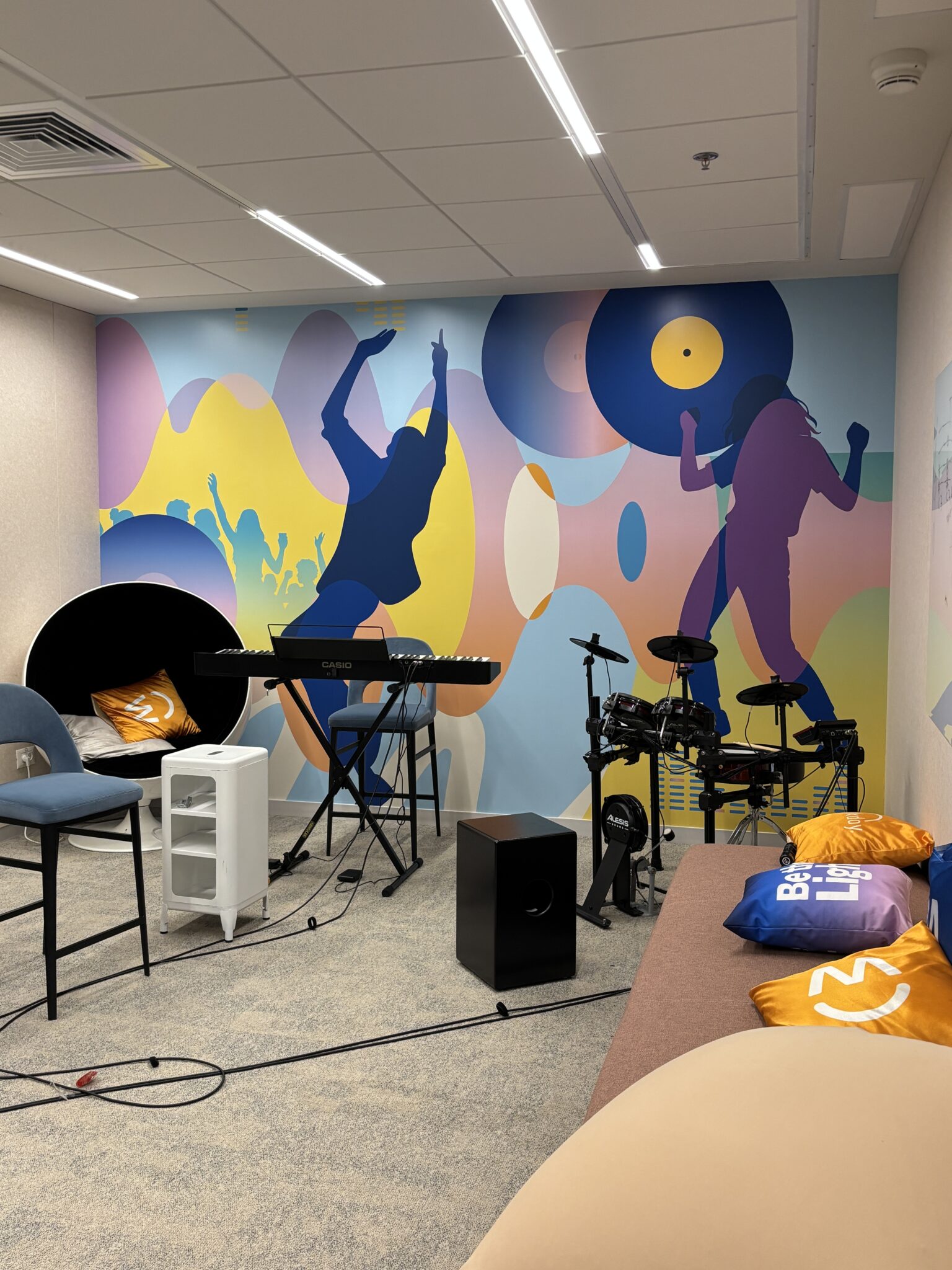 Music room with drums, keyboard and a colourful dancers wall mural