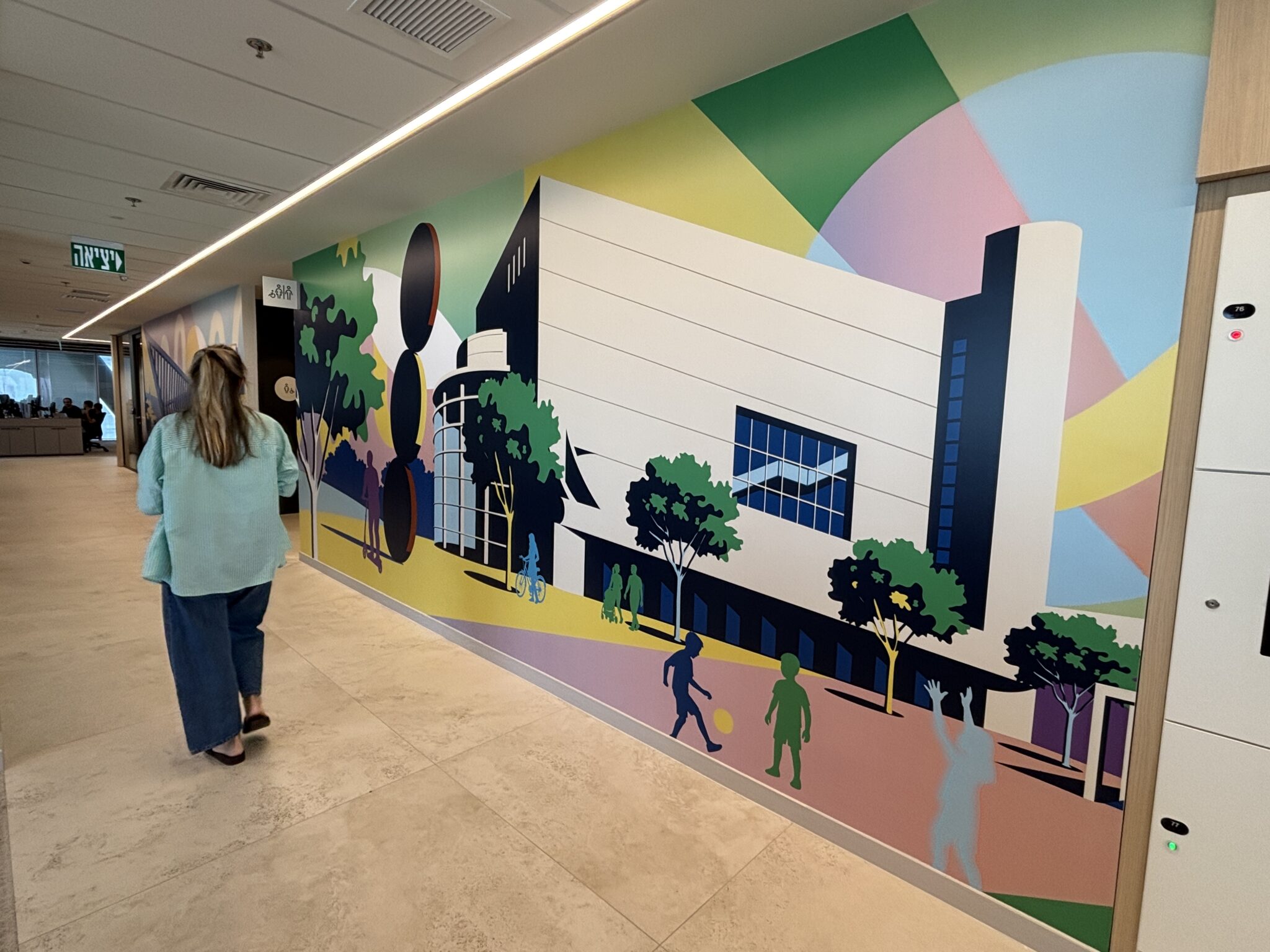 Woman walking past a colourful city museum illustration mural