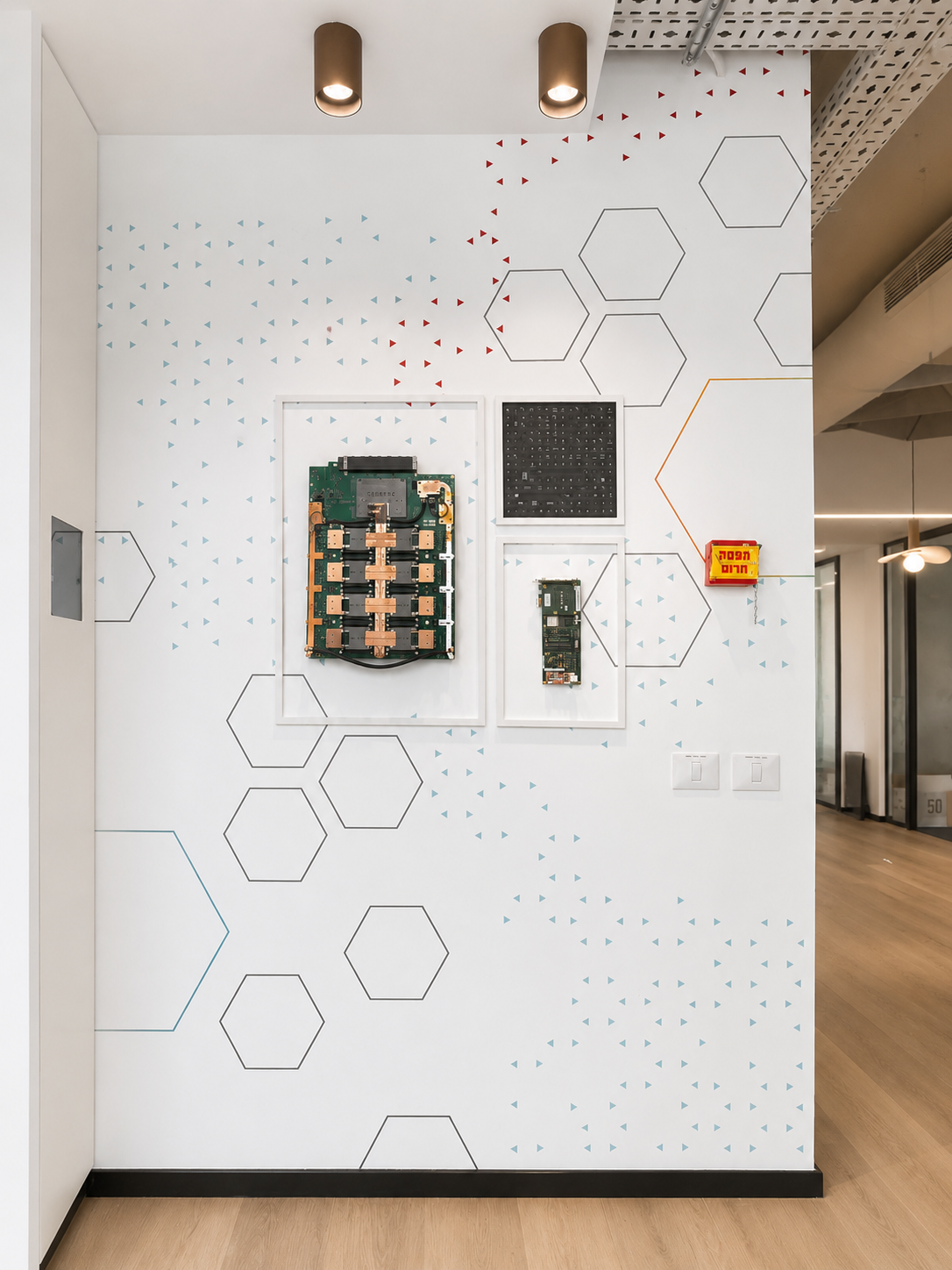 Framed circuit boards on a white wall with hexagon graphics