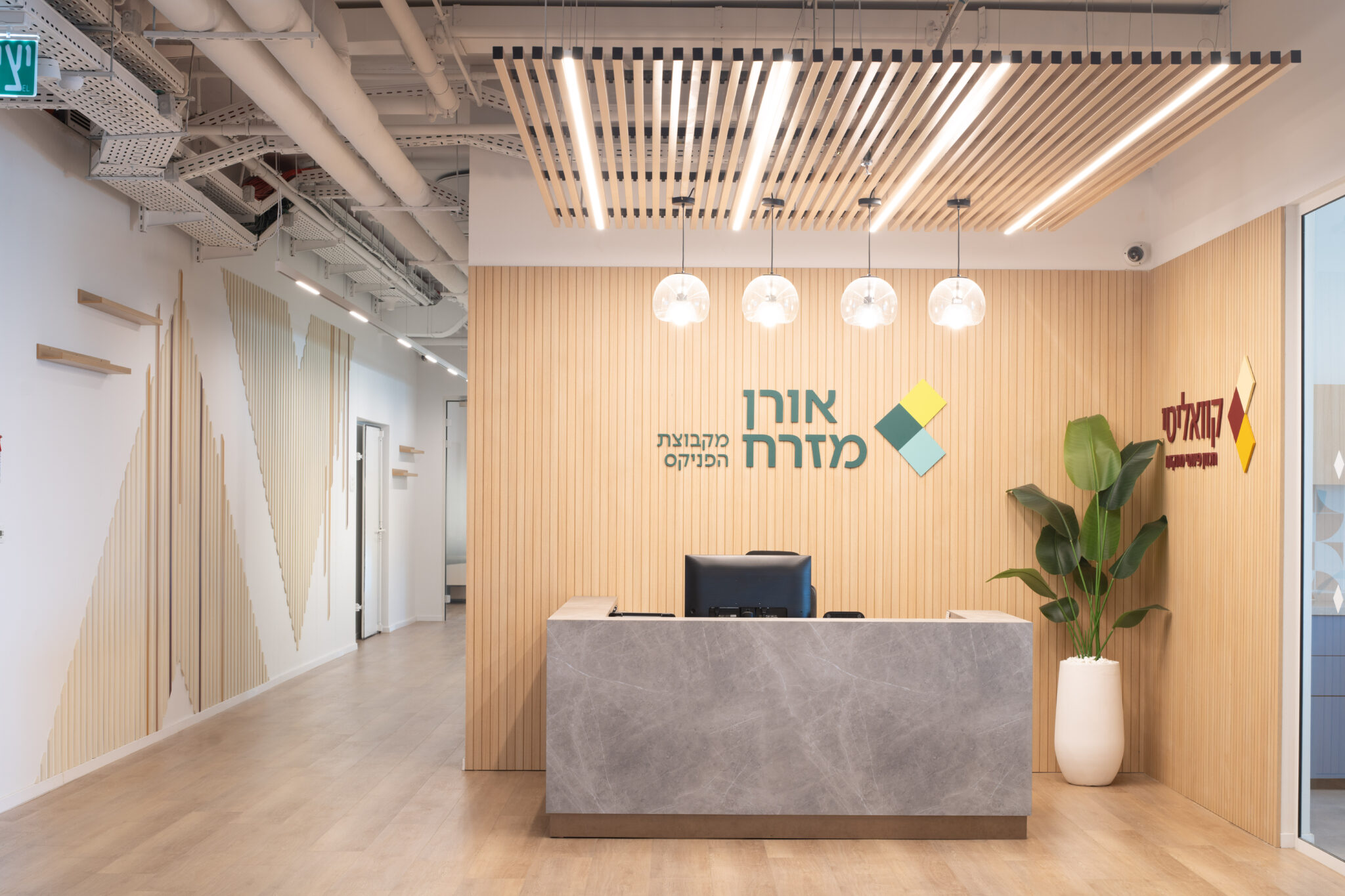 Oren Mizrah logo above a stone reception desk with wood slats