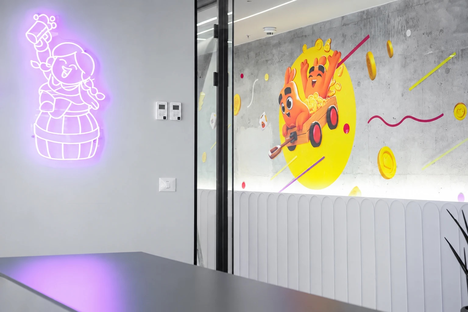 Purple neon character sign in a meeting room beside a wall graphic